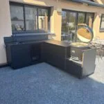 Mado Prestige Cuisine extérieure sur mesure en angle finition noire avec évier frigo et kamado